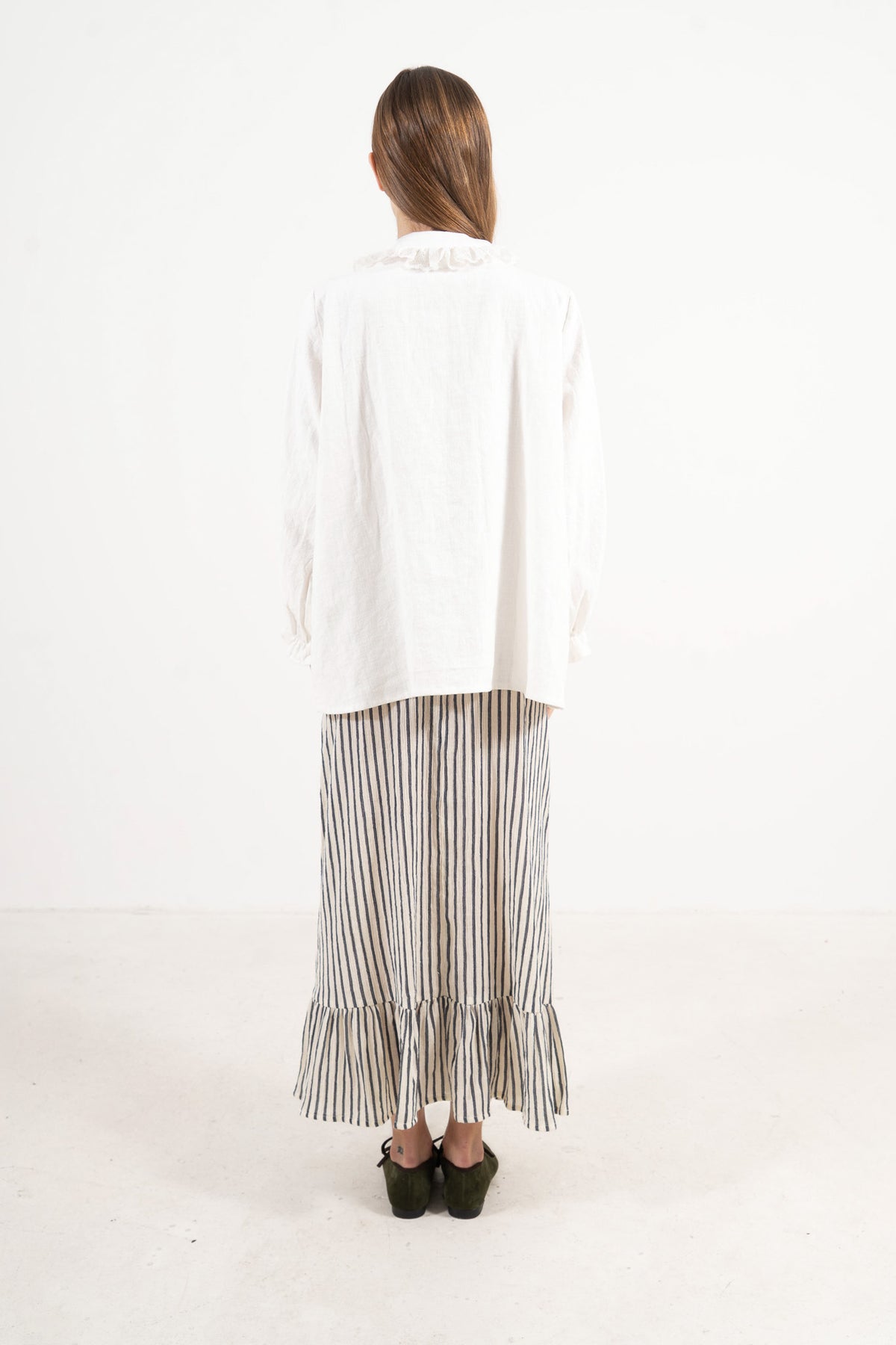 Back view of the timeless organic cotton blouse on a model, capturing a sense of ease and understated femininity.