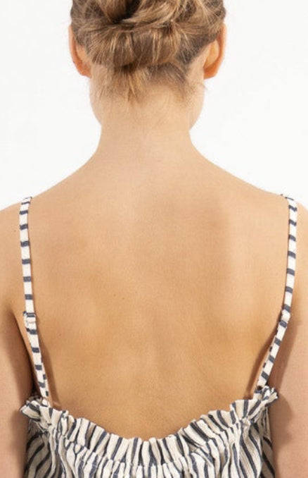 Minimalist back view of the cotton top on a model, illustrating a softly elevated look and timeless aesthetic.