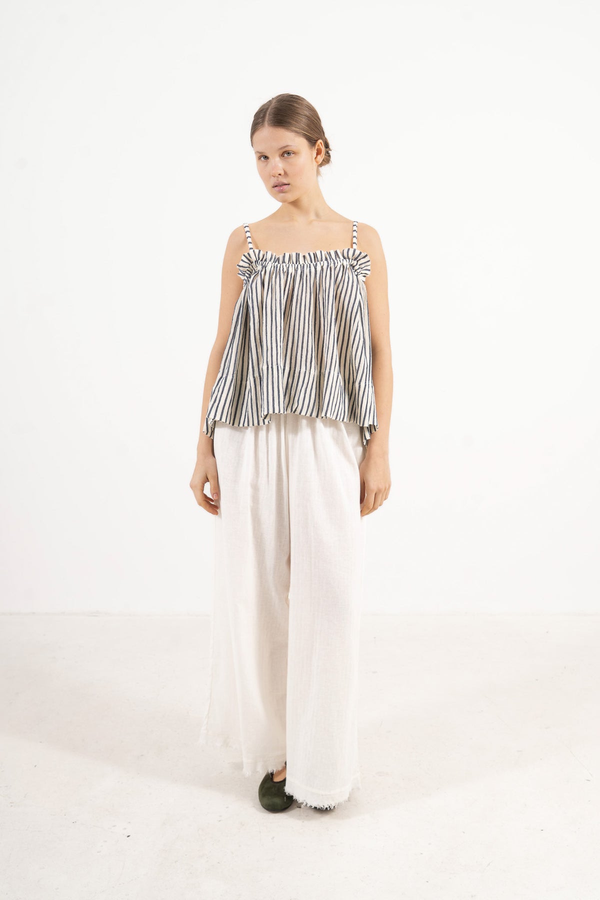 Side lookbook capture of the striped cotton top, emphasizing its light, airy drape inspired by movement and gentle days.