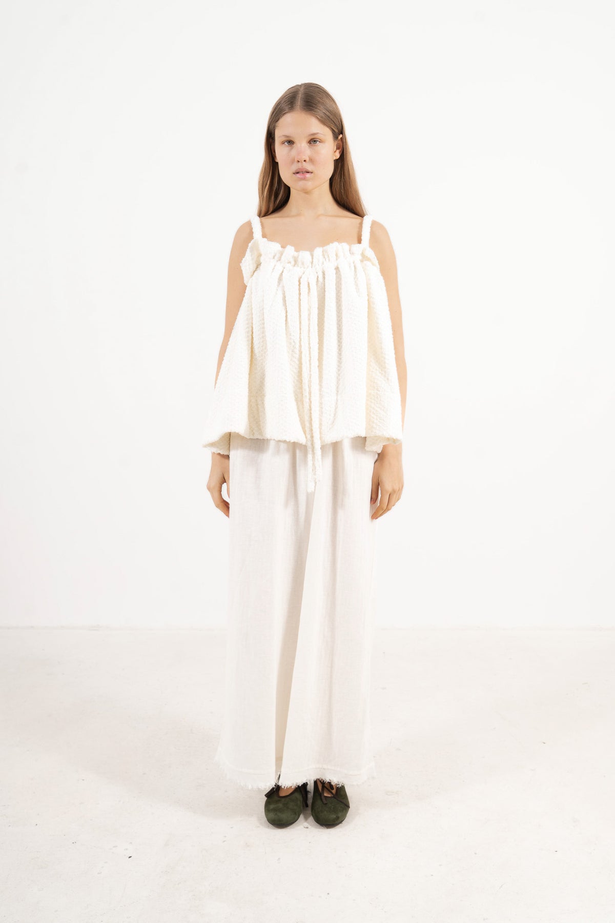 Front view studio portrait featuring a model in the white soft cotton Adeline top by MOCHA, capturing its quiet femininity and effortless elegance.