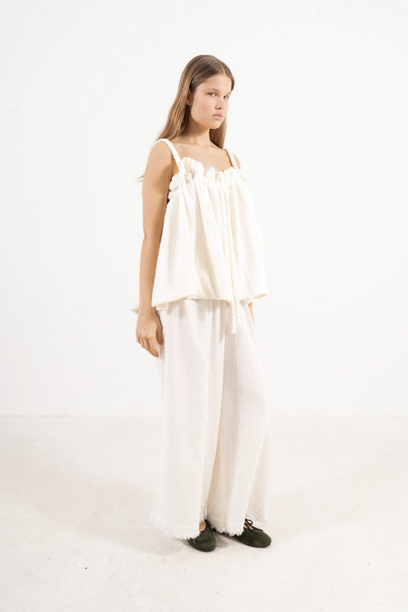 Side lookbook capture of the premium white cotton top, emphasizing its light, airy drape inspired by movement and gentle days.