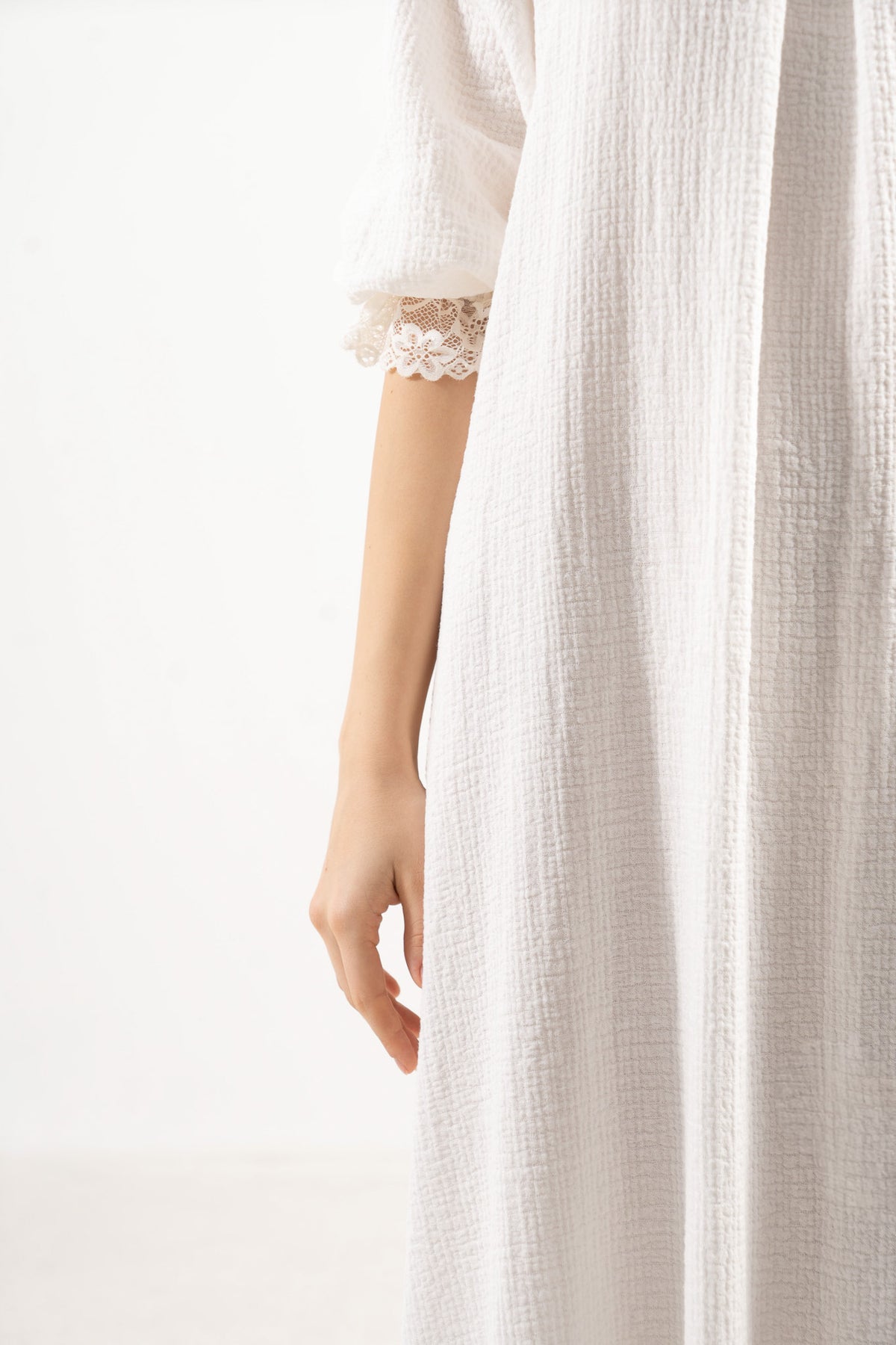 An exquisite close-up detail of the MOCHA Aérienne dress, celebrating the fine soft cotton weave, gentle structural elements, and superior fabric texture.