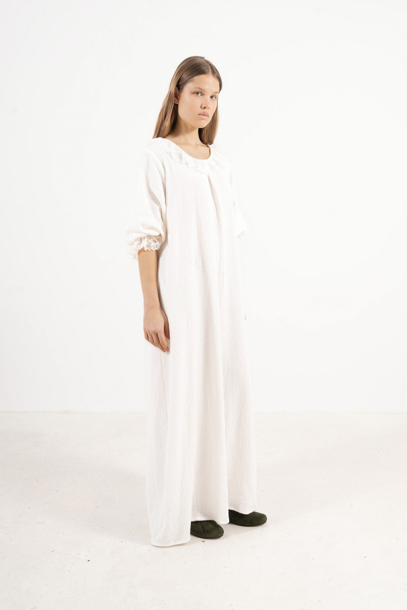 A poetic side angle view of the luxury soft cotton MOCHA Aérienne garment, showcasing its light, timeless silhouette cascading softly against a white backdrop.