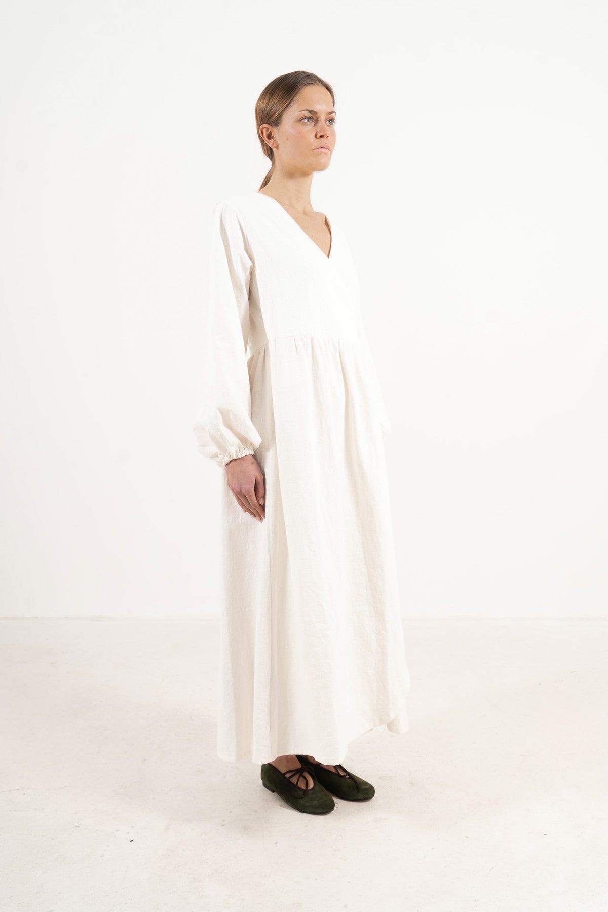 Woman wearing the Mocha Amadea cotton dress, three-quarter profile view