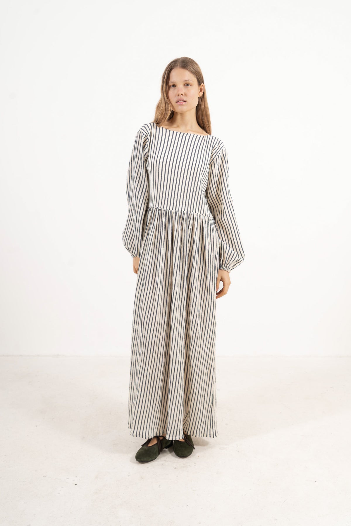 Profile studio portrait showcasing the refined long silhouette, adjustable straps, and pure structure of the MOCHA Amadea dress.