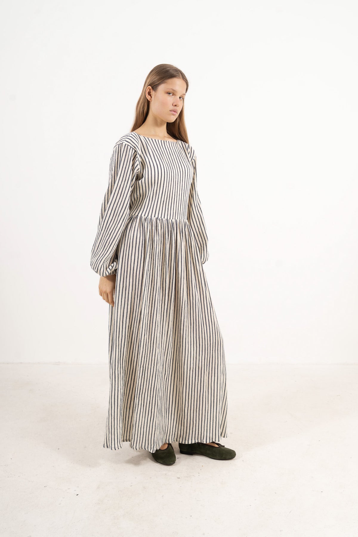 Side lookbook capture of the striped organic cotton dress, emphasizing the beautiful, effortless flow inspired by air and movement.
