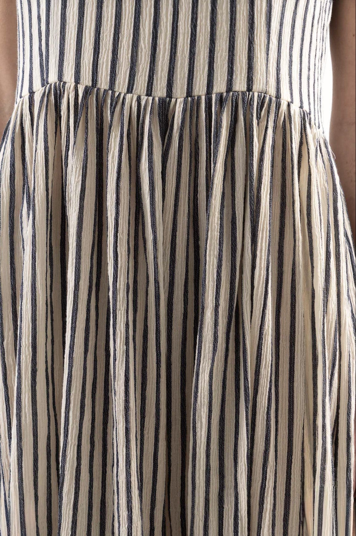 Close-up detail shot focusing on the delicate fine stripe texture and premium weave of the pure MOCHA organic cotton fabric.