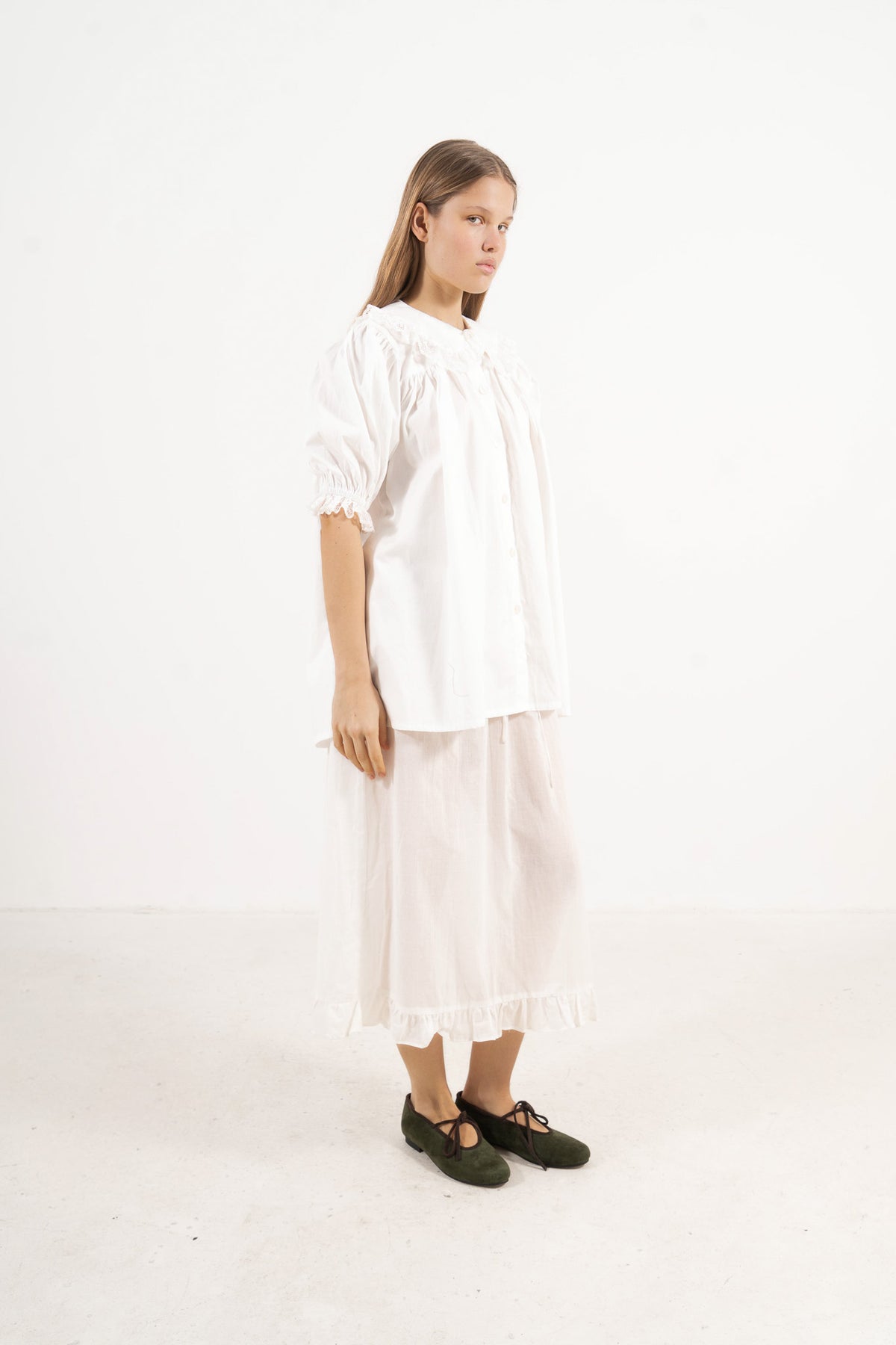 Profile studio portrait showcasing the relaxed fit, pure structure, and graceful lines of the MOCHA Amour blouse.