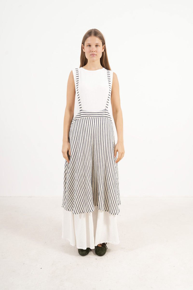 Full-length front view of a fashion model wearing the long MOCHA apron skirt with shoulder straps made from white cotton.
