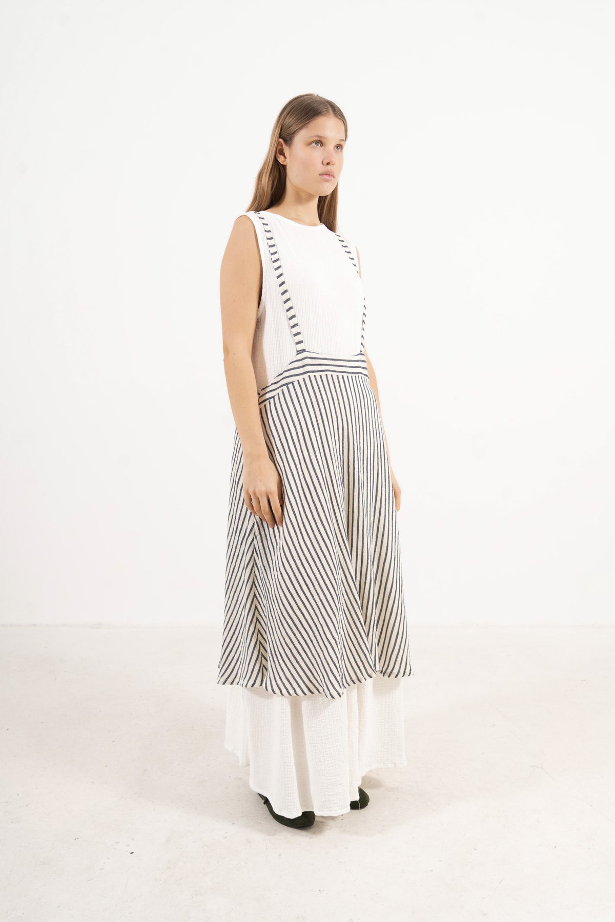 Side profile view of the MOCHA apron skirt showing its depth, strap placement, and long flowing silhouette.