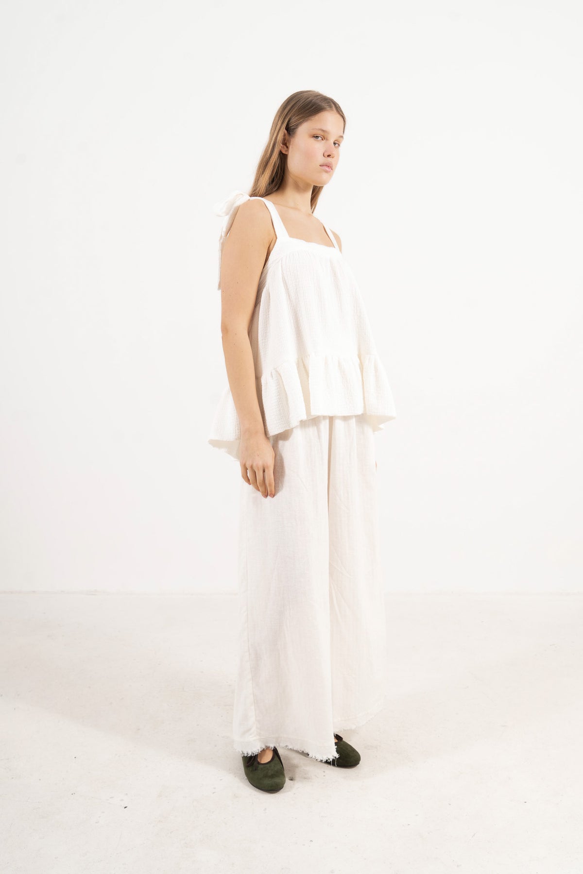 Profile studio portrait showcasing the versatile fit, clean lines, and pure structure of the MOCHA Belle top.