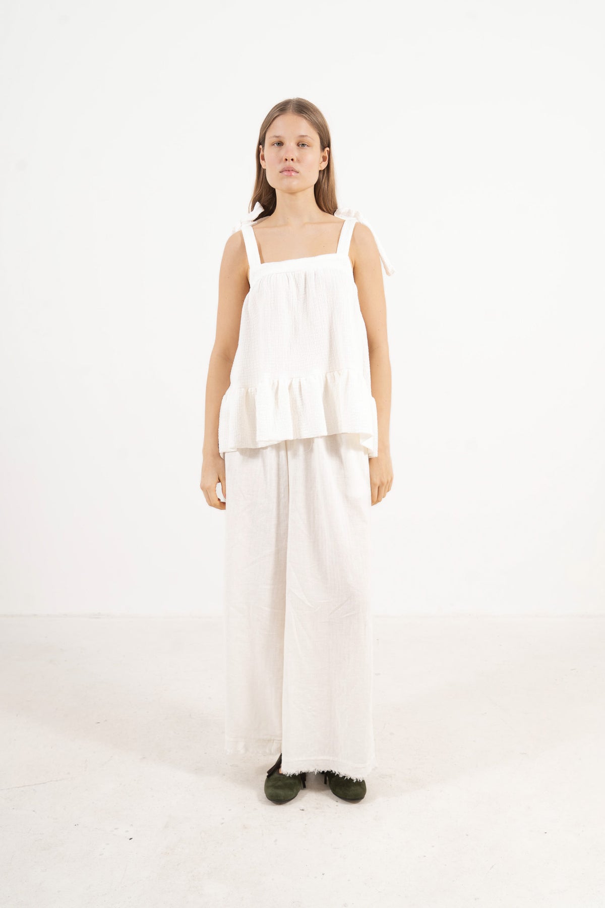 Side lookbook capture of the organic cotton top with straps, emphasizing its light, airy drape inspired by movement and gentle days.
