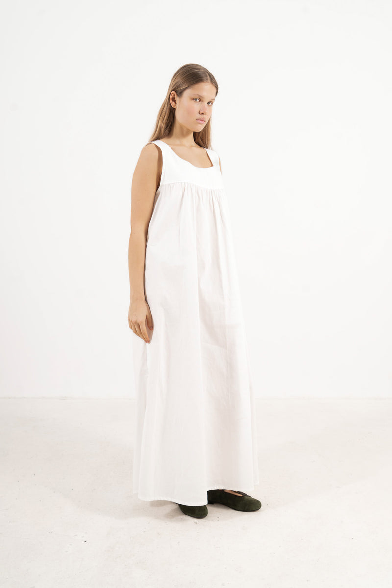 Side lookbook capture of the white cotton dress, emphasizing how the flowing fabric and generous length move easily with every step.