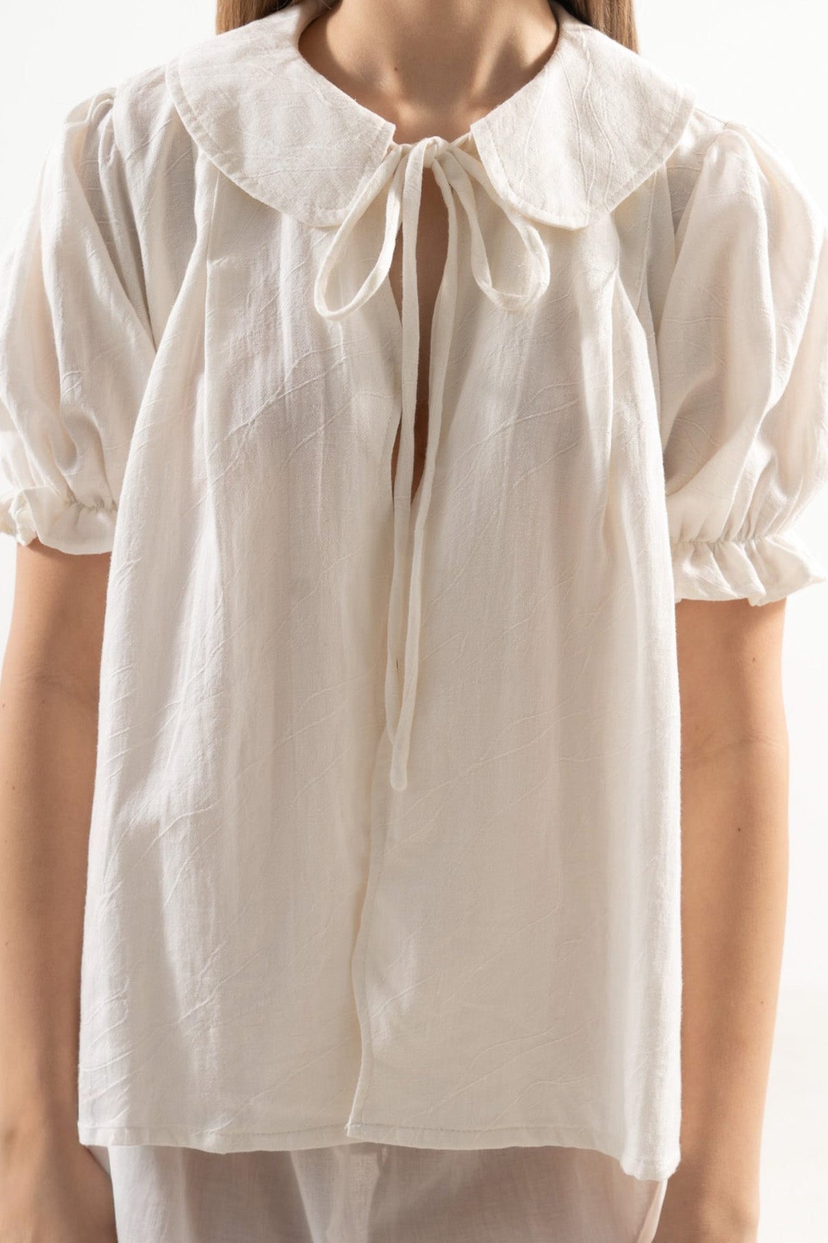 Close-up detail shot focusing on the delicate accents, center strap closure, and premium weave of the pure MOCHA cotton fabric.