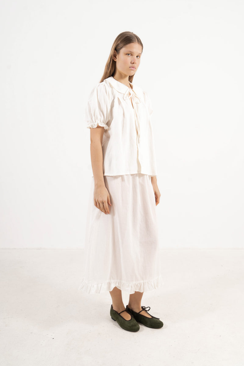 Side lookbook capture of the white cotton blouse, emphasizing the beautiful, lightweight drape inspired by air, movement, and gentle days.