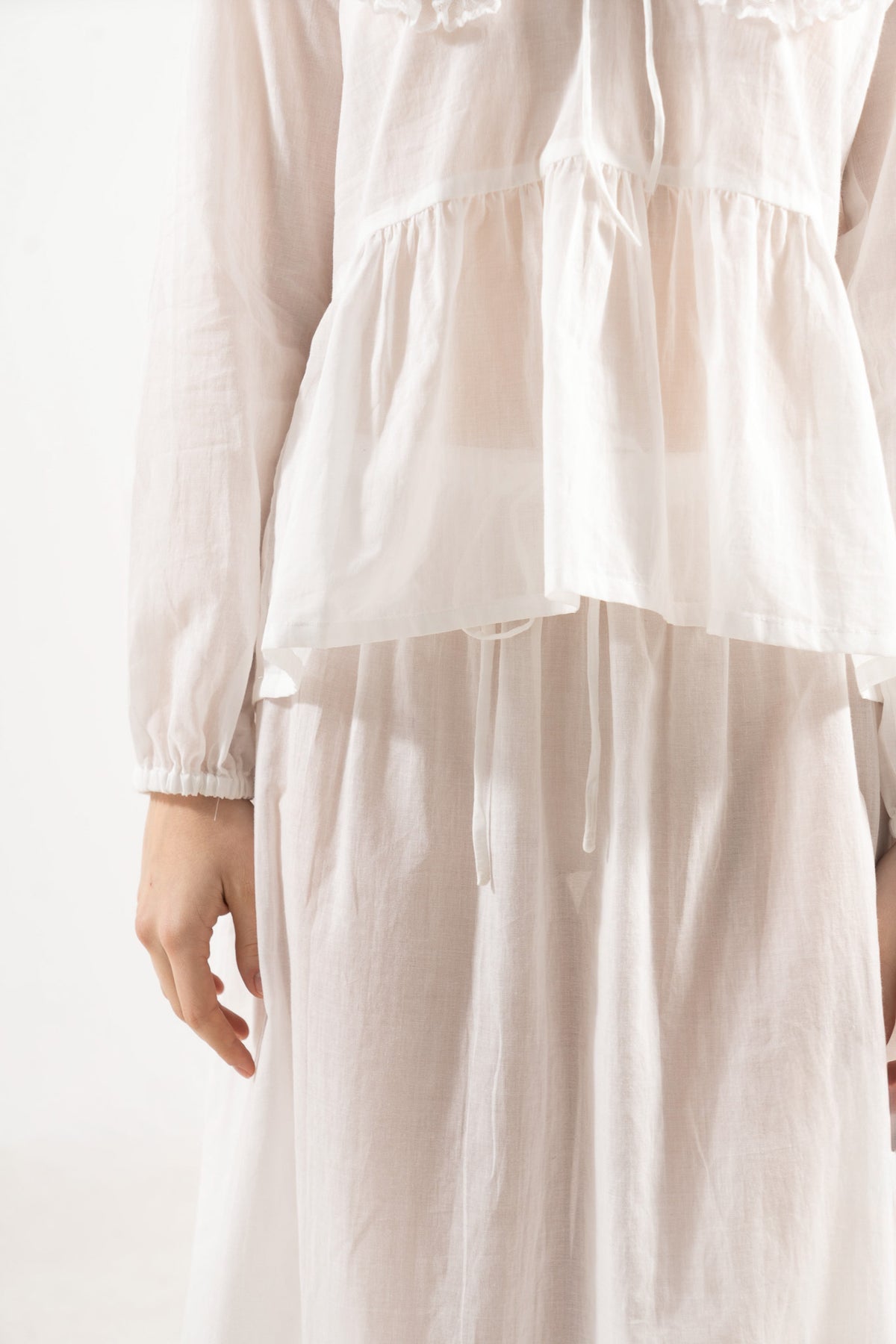 Close-up detail shot focusing on the fine stitching, delicate collar accents, and premium weave of the pure MOCHA organic white cotton fabric.