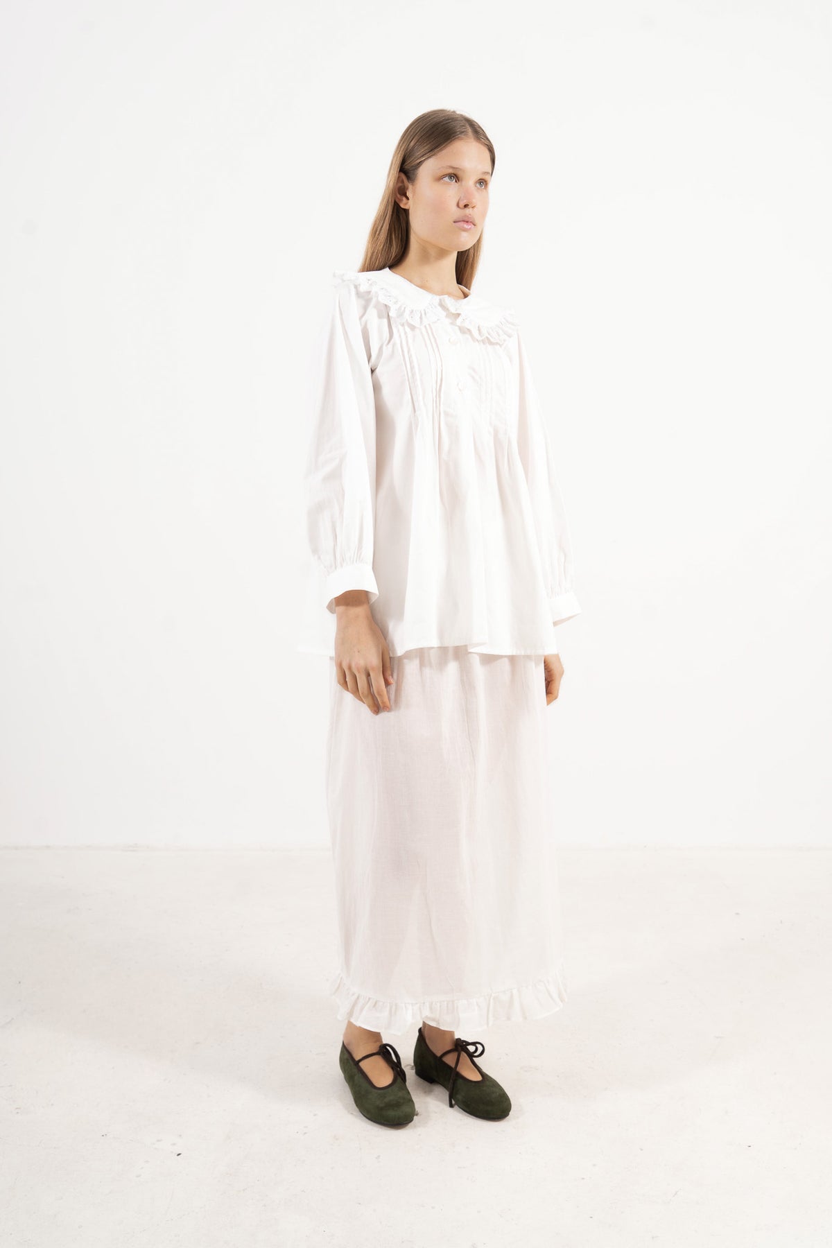 Profile studio portrait showcasing the refined minimalist tailoring, clean lines, and soft structural aesthetic of the MOCHA blouse.