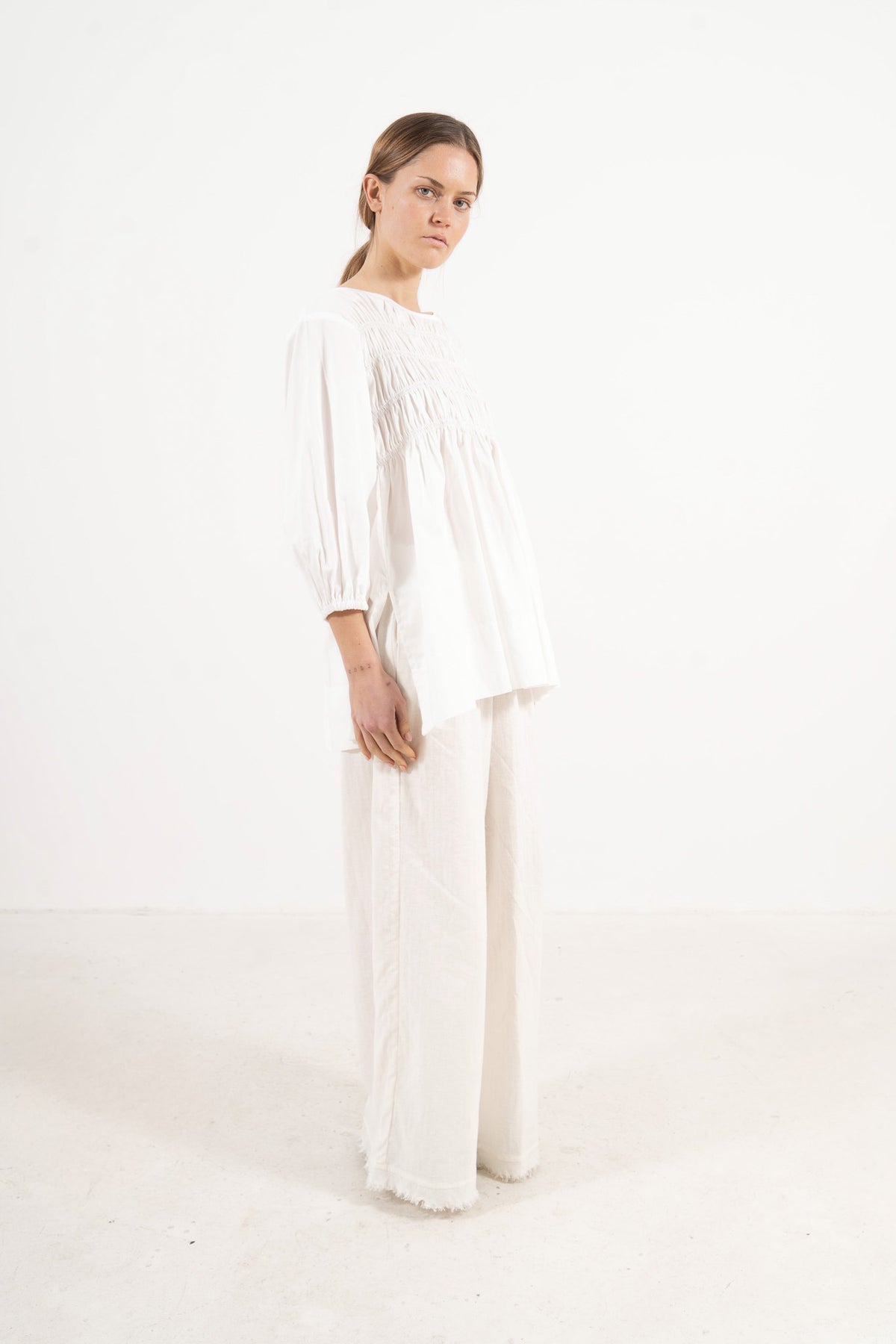 Side lookbook capture of the premium cotton blouse, emphasizing the beautiful, fluid movement of the sleeves inspired by the timeless grandeur of the French court.