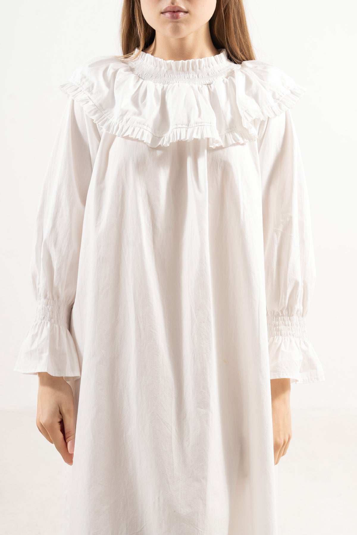 Close-up detail shot focusing on the intricate embellishments, delicate collar design, and premium weave of the MOCHA organic cotton fabric.