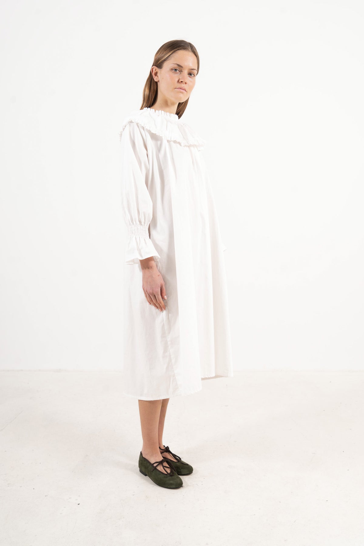 Profile studio portrait showcasing the refined structure, aristocratic grace, and commanding presence of the MOCHA Lucienne dress.