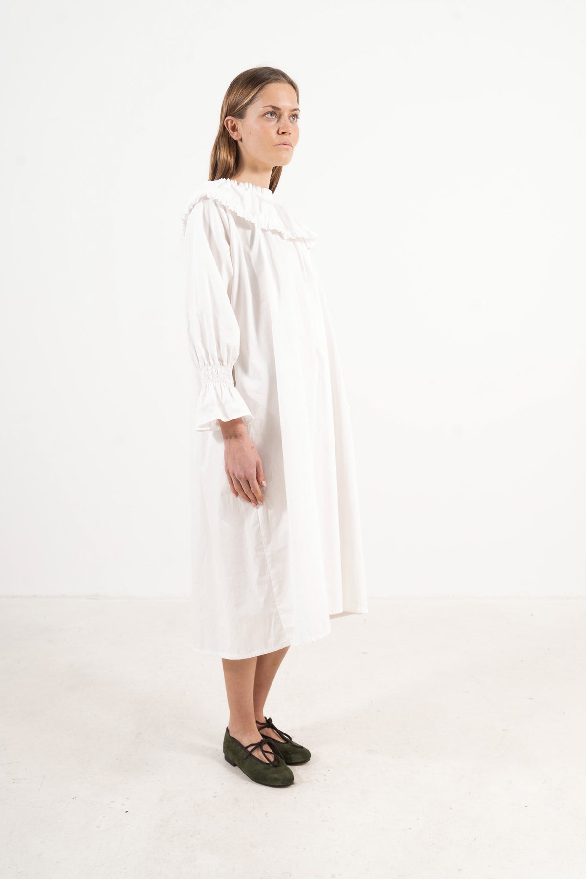 Profile studio portrait showcasing the refined structure, aristocratic grace, and commanding presence of the MOCHA Lucienne dress.