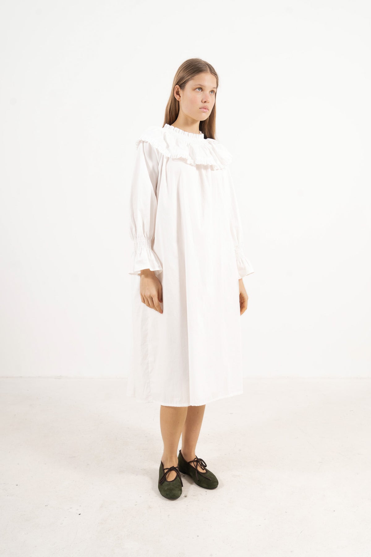Profile studio portrait showcasing the refined structure, aristocratic grace, and commanding presence of the MOCHA Lucienne dress.