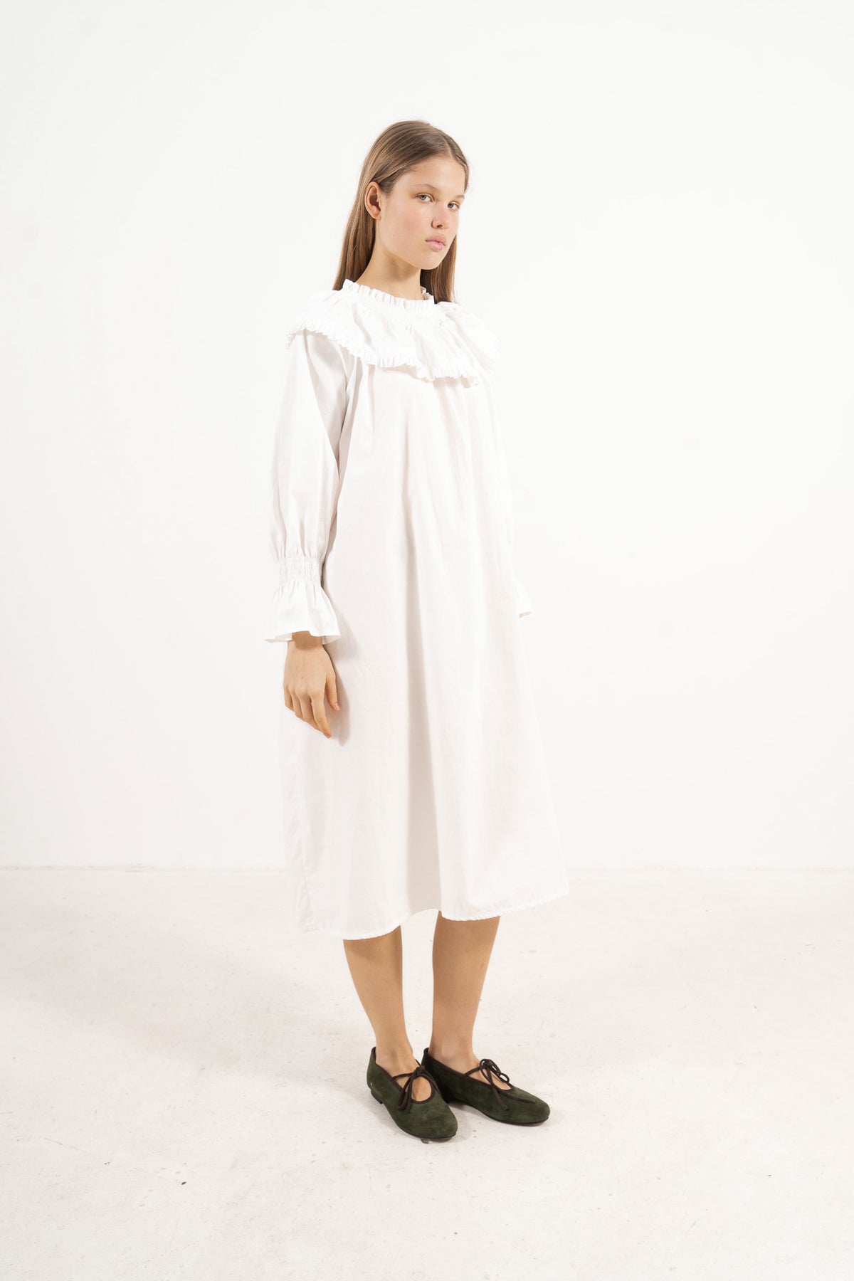 Side lookbook capture of the long organic cotton dress, emphasizing the beautiful, fluid drape inspired by the timeless grandeur of the French court.