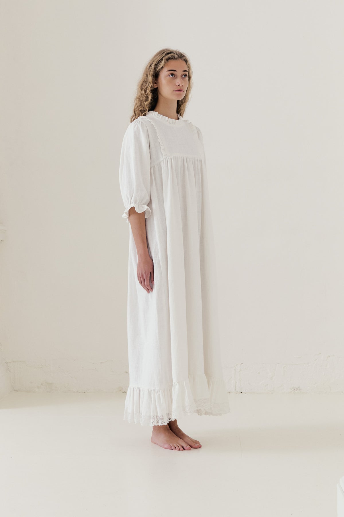 Side profile view of the MOCHA La Robe Noblesse dress showcasing the elegant drape and full-length silhouette.