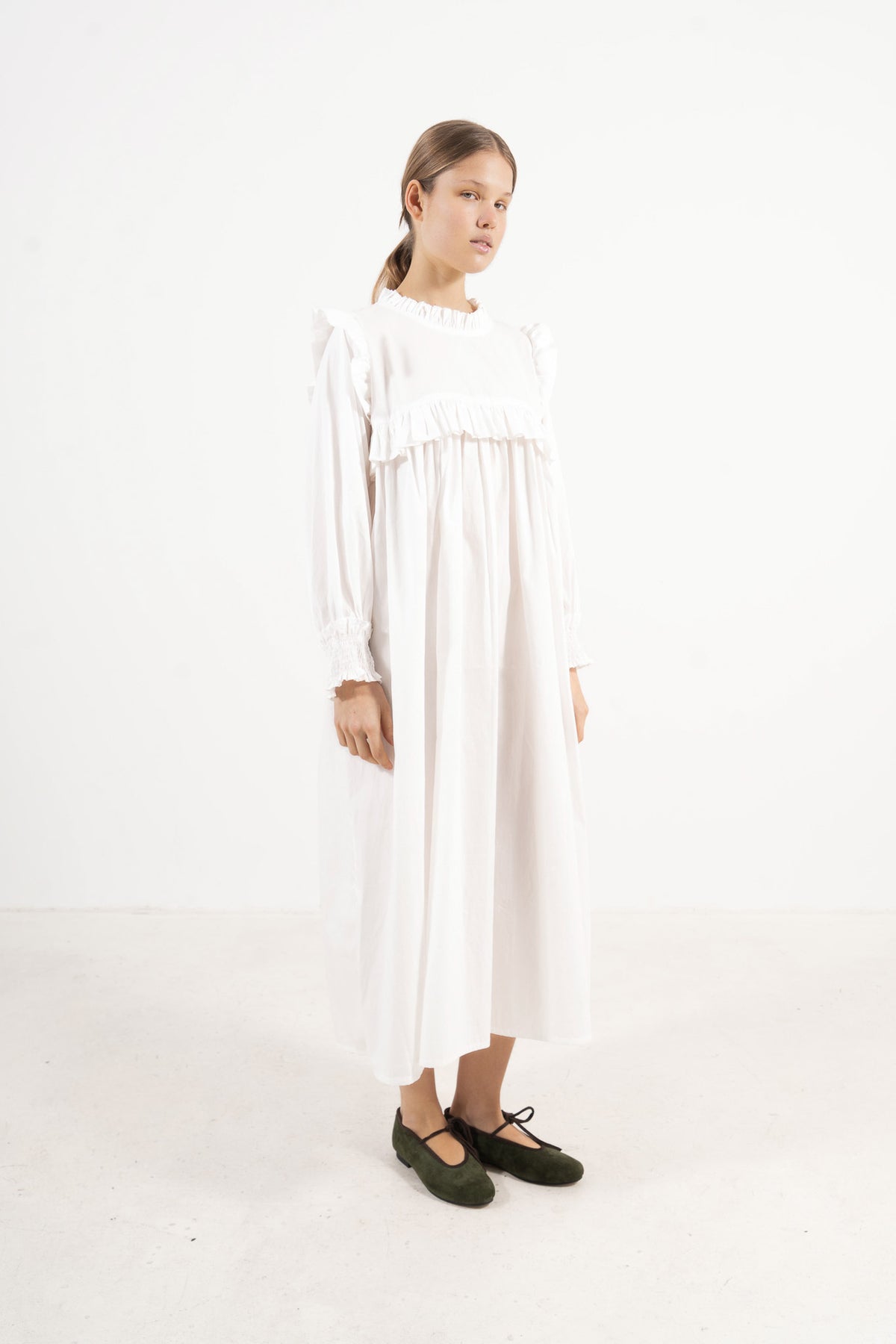 Side lookbook capture of the long organic cotton dress, emphasizing the beautiful, fluid drape inspired by the timeless grandeur of the French court.