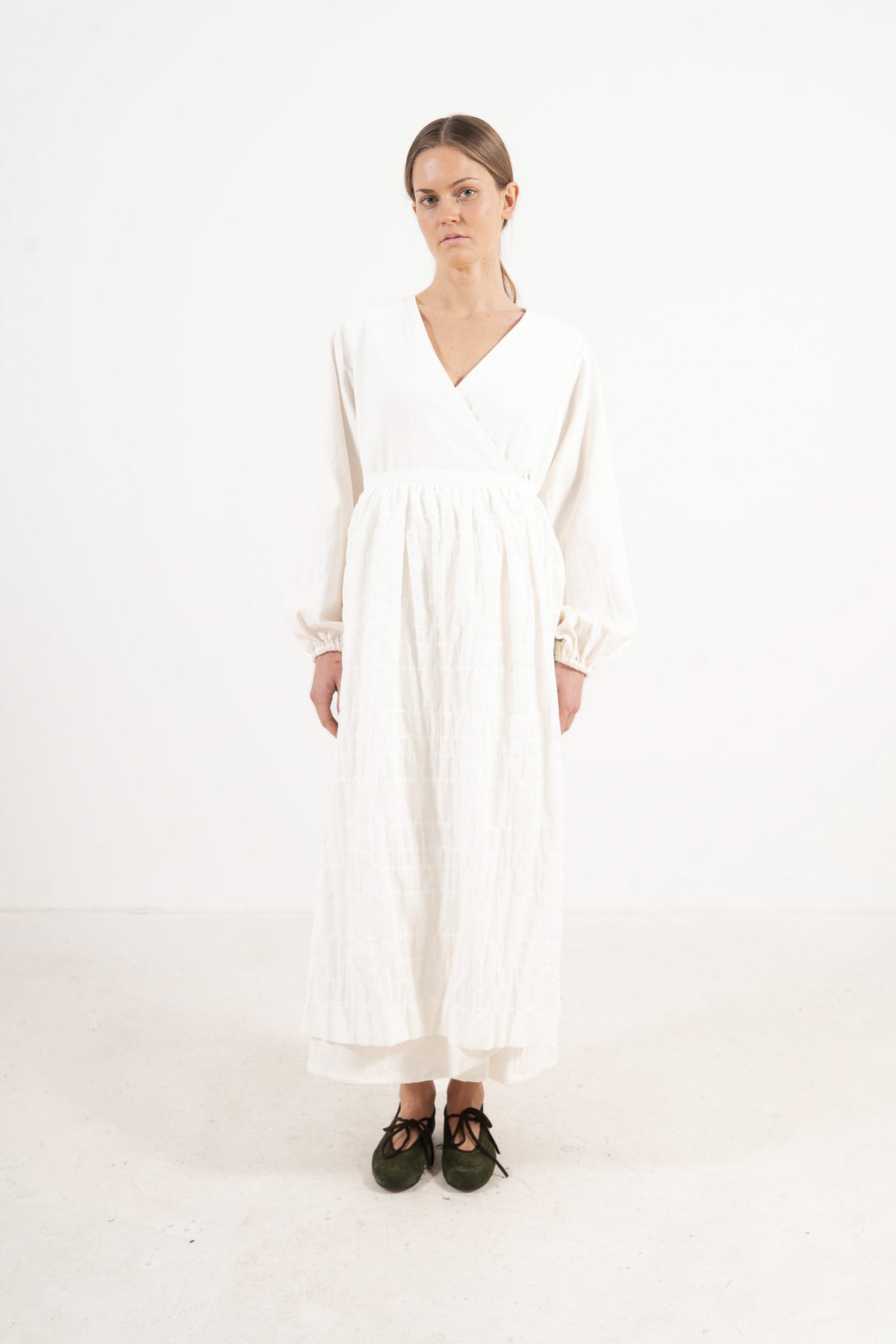 Front view lookbook image featuring a model wearing the ruffled Le Tablier long apron by MOCHA, inspired by the quiet poetry of home.