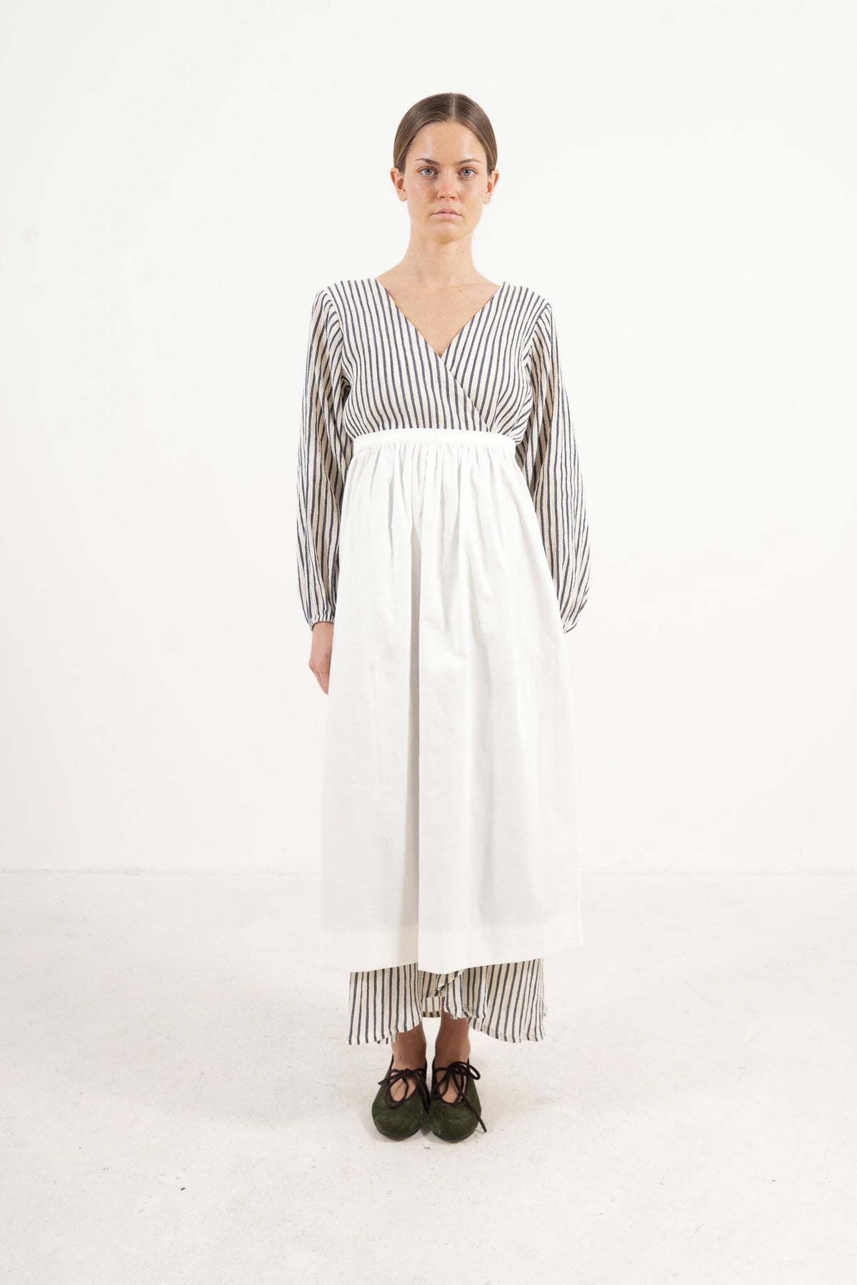 Front view lookbook image featuring a model wearing the ruffled Le Tablier long apron by MOCHA, inspired by the quiet poetry of home.