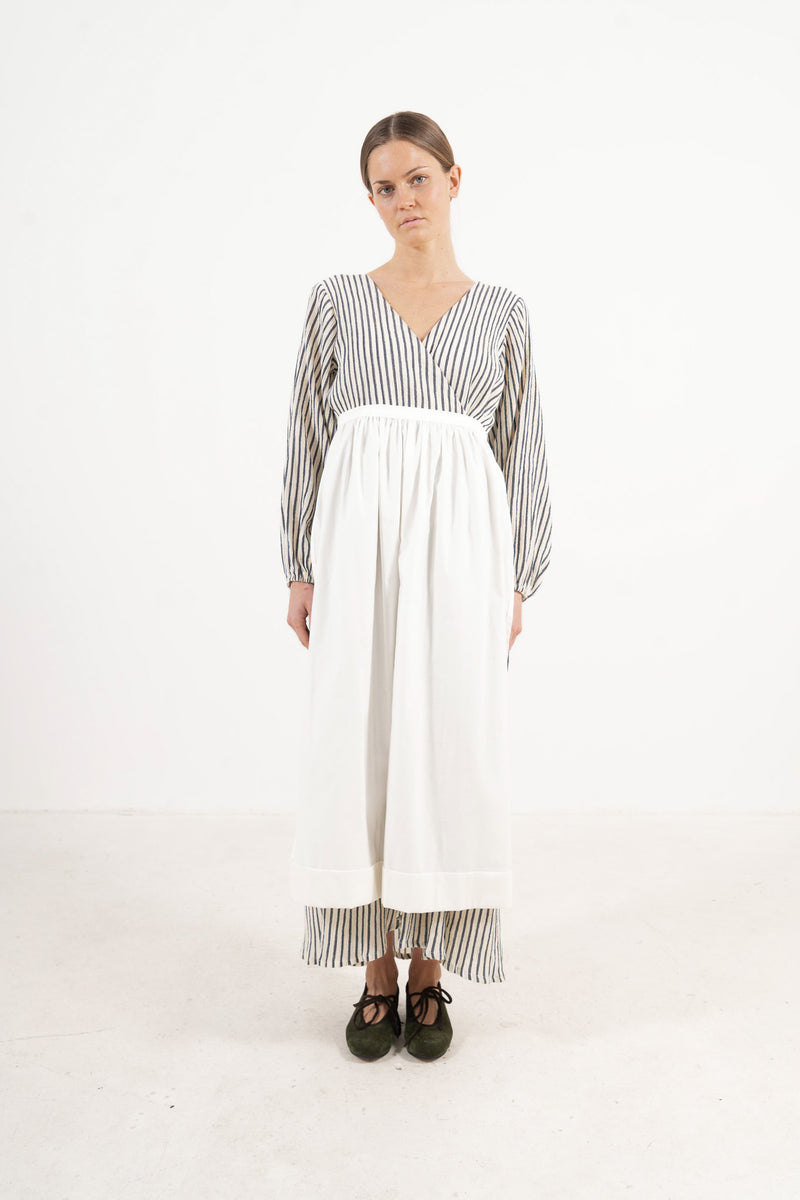 Front view lookbook image featuring a model wearing the ruffled Le Tablier long apron by MOCHA, inspired by the quiet poetry of home.
