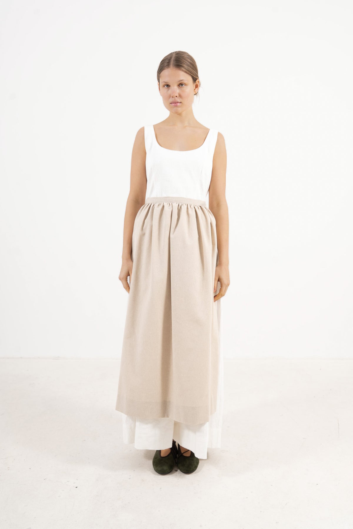 Front view lookbook image featuring a model wearing the ruffled Le Tablier long apron by MOCHA, inspired by the calm poetry of home.