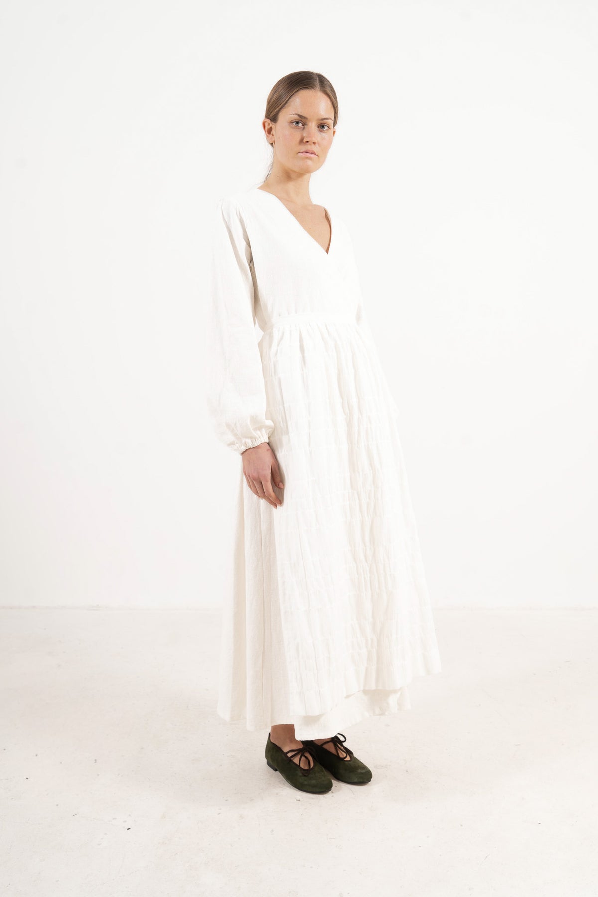Side profile capture of the pure cotton long apron, illustrating how it serves as an elegant accessory that brings charm and character to everyday moments.
