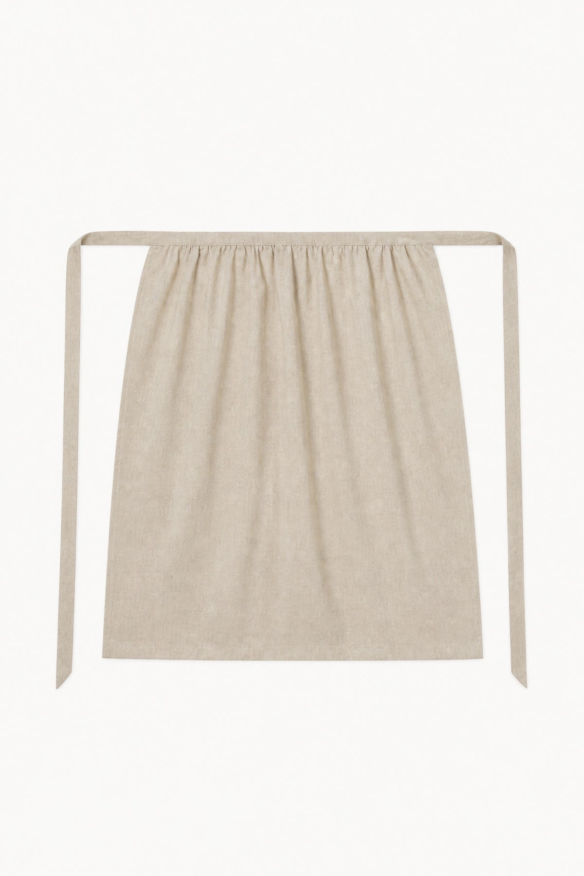 Minimalist flat lay of the MOCHA Le Tablier mid apron in beige, showcasing the pure cotton structure and timeless beauty of traditional design.