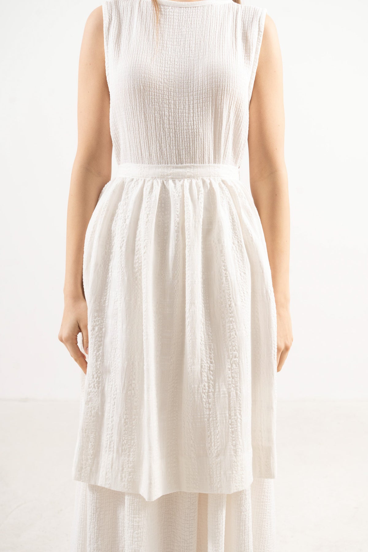 Detailed close-up showing the delicate volants, clean stitching, and pure cotton texture of the MOCHA Le Tablier apron.