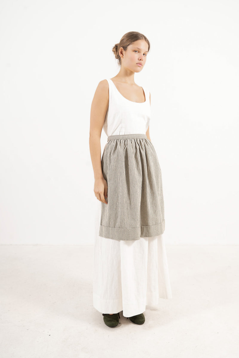 Side profile capture of the striped cotton mid apron, illustrating how it serves as an elegant accessory that brings charm and character to everyday moments.