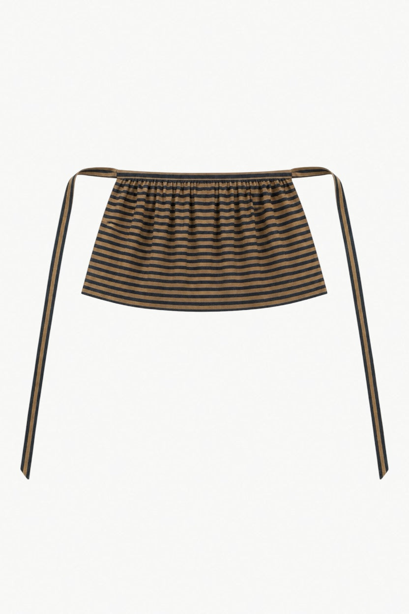 Minimalist flat lay of the MOCHA Le Tablier mini apron, showcasing the fine striped cotton structure and timeless beauty of traditional design.