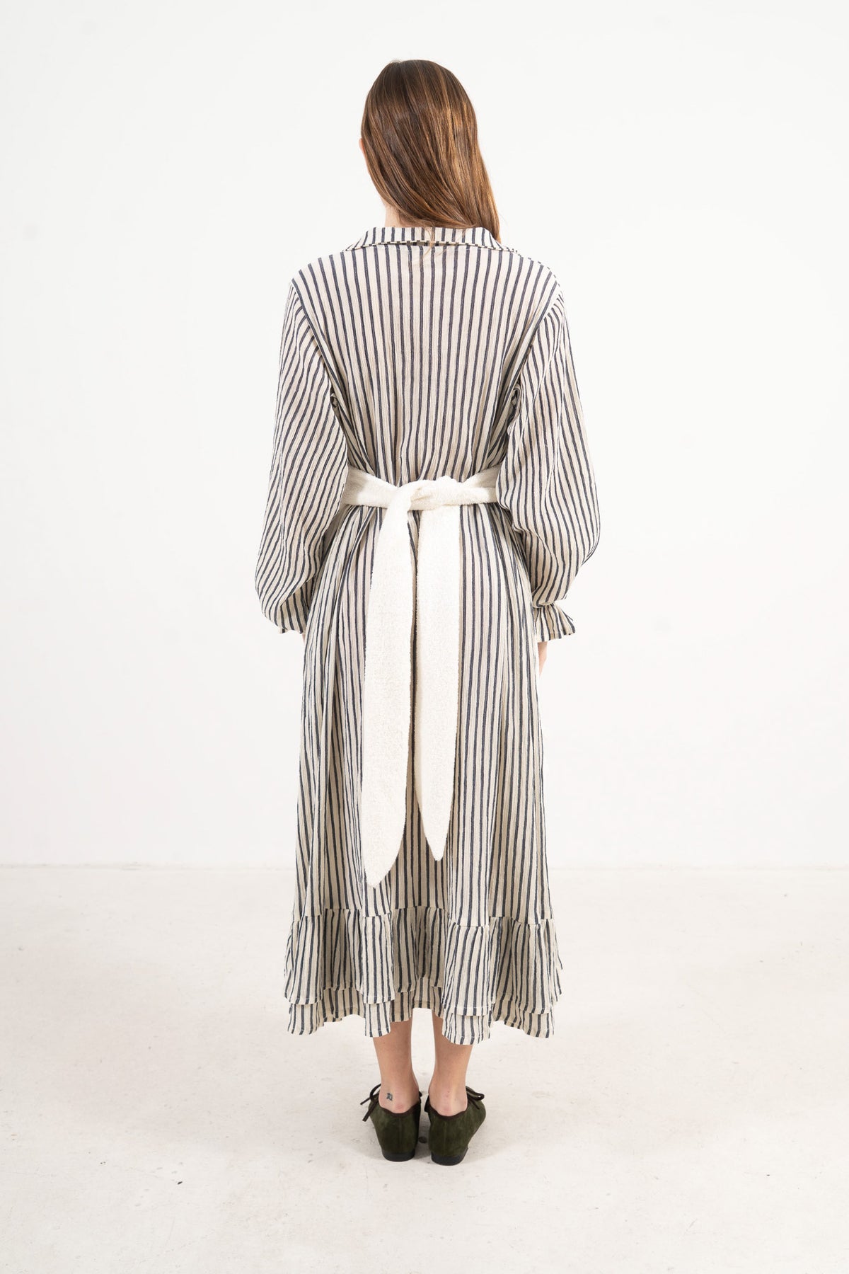 Back view of the mid apron on a model, showcasing the delicate tie straps and the fine craftsmanship of the piece.