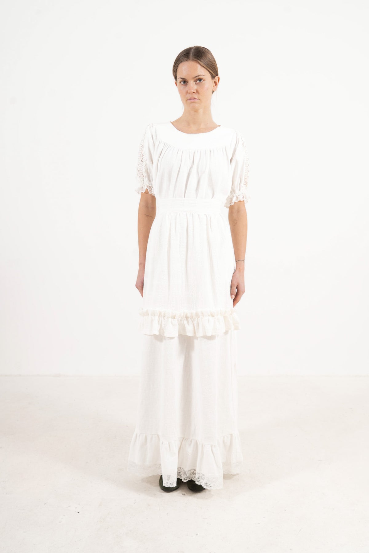 Front view lookbook image featuring a model wearing the ruffled Le Tablier Volanté mid apron by MOCHA, inspired by the calm poetry of home.