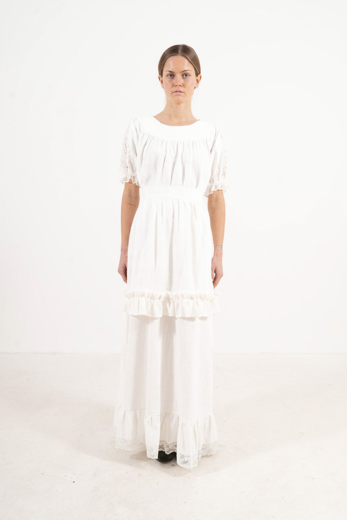 Front view lookbook image featuring a model wearing the ruffled Le Tablier Volanté mid apron by MOCHA, inspired by the calm poetry of home.