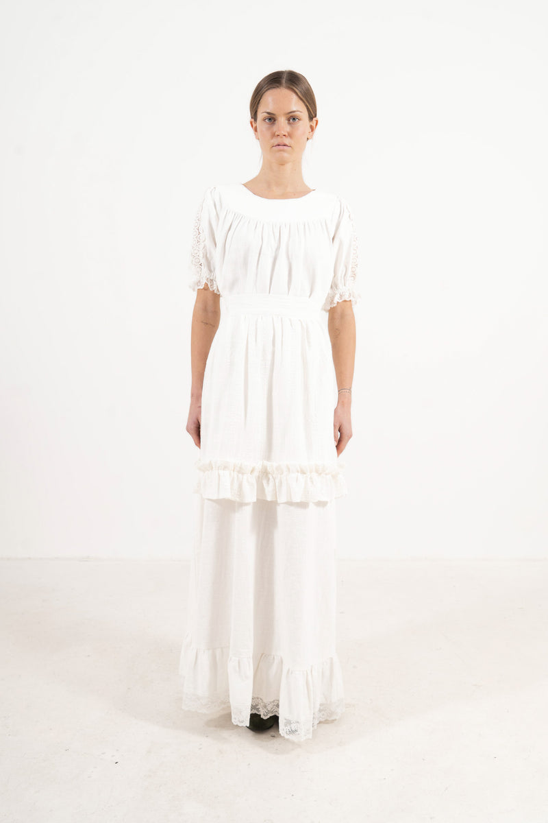 Front view lookbook image featuring a model wearing the ruffled Le Tablier Volanté mid apron by MOCHA, inspired by the calm poetry of home.