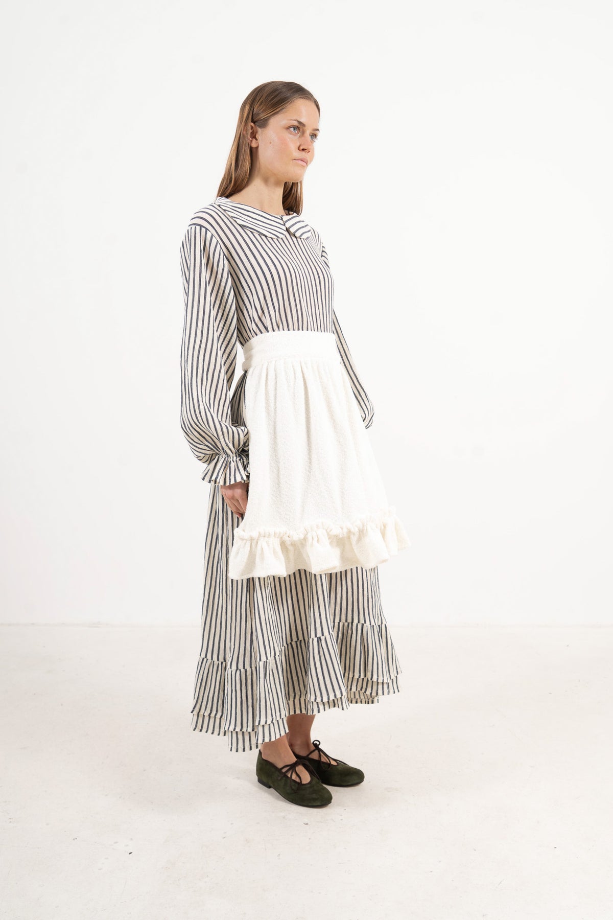 Studio lookbook portrait highlighting the elegant, relaxed silhouette and clean styling of the MOCHA cotton apron.