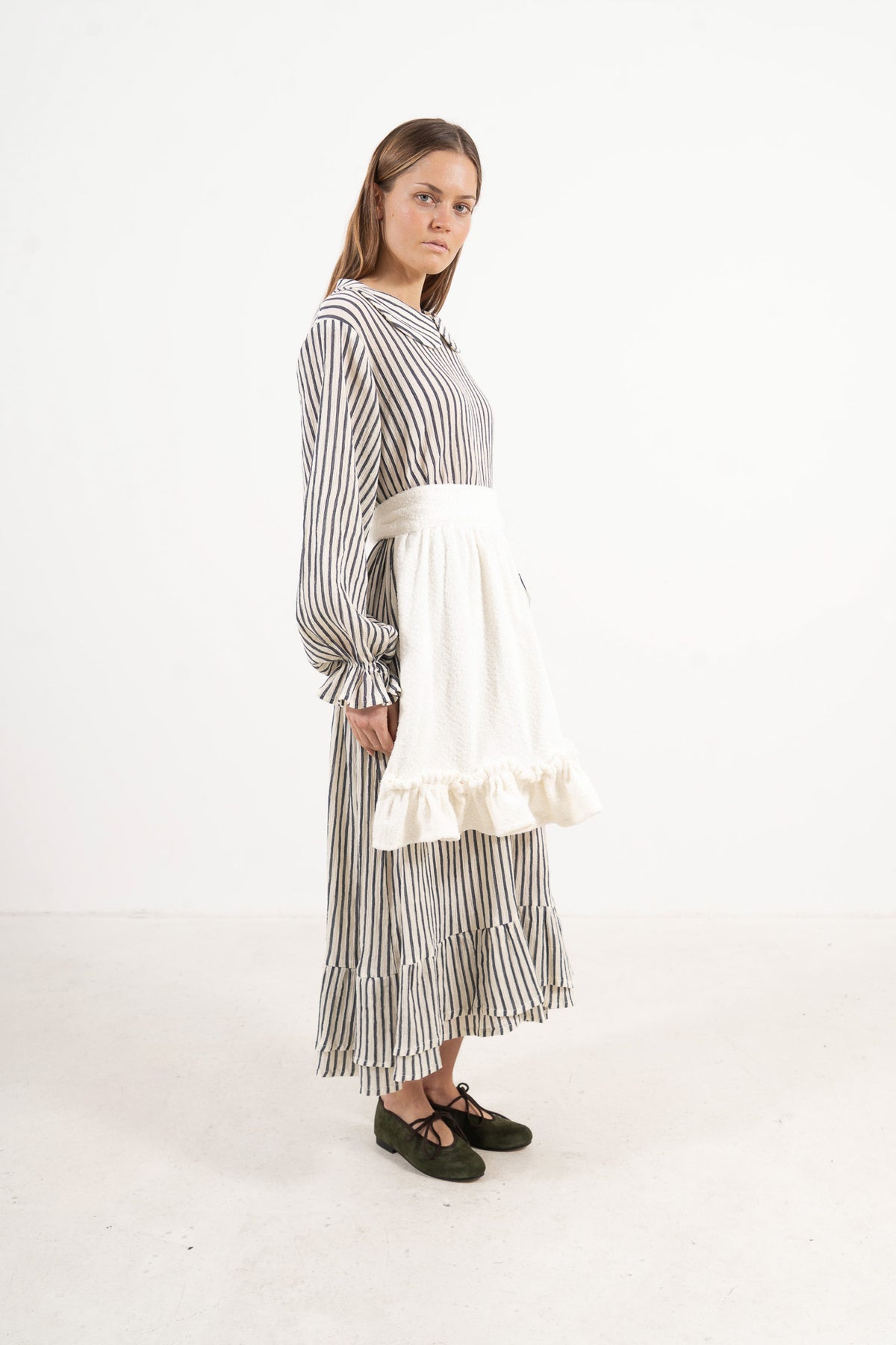 Side profile capture of the pure cotton mid apron, illustrating how it serves as a unique accessory that brings charm to every look.