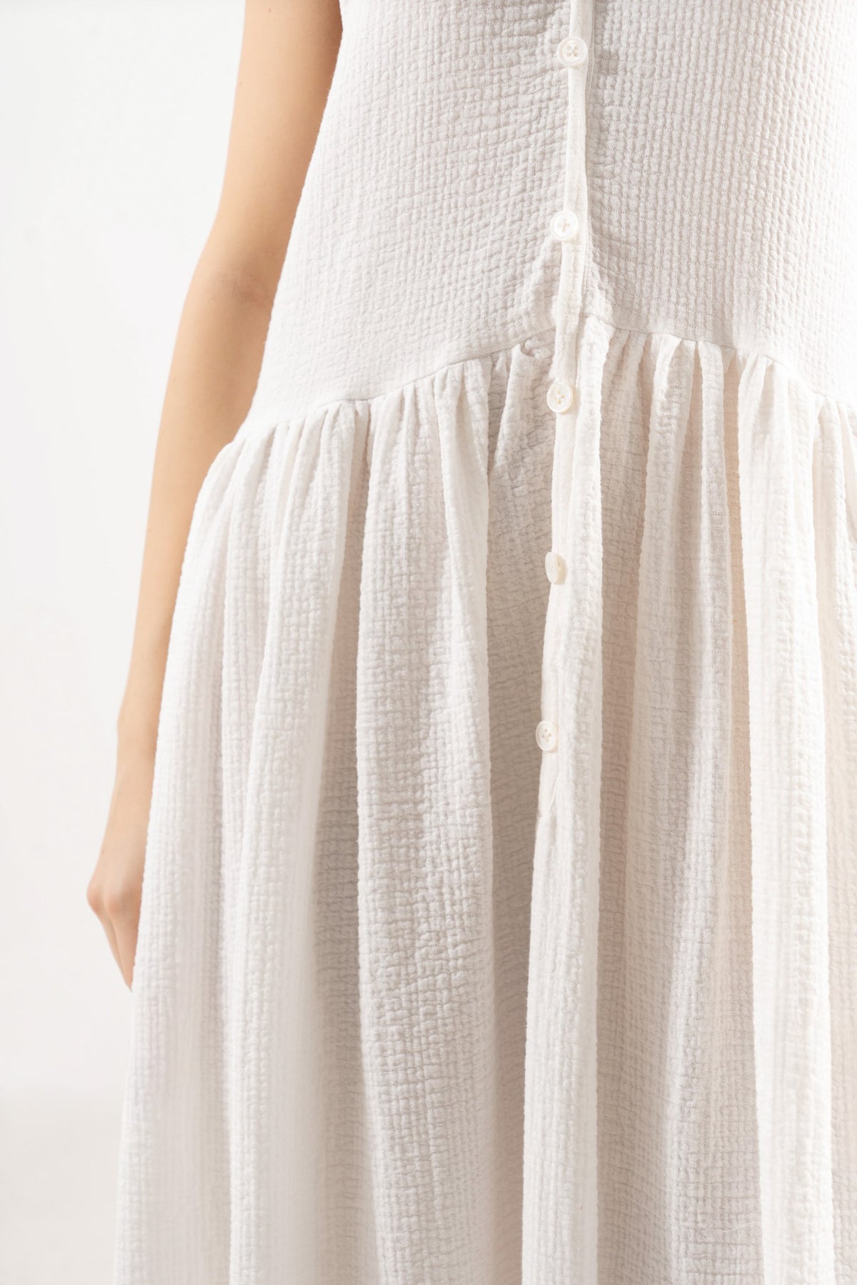 An exquisite close-up detail of the MOCHA Nuage dress, celebrating the fine soft cotton weave, gentle structural elements, and superior fabric texture.