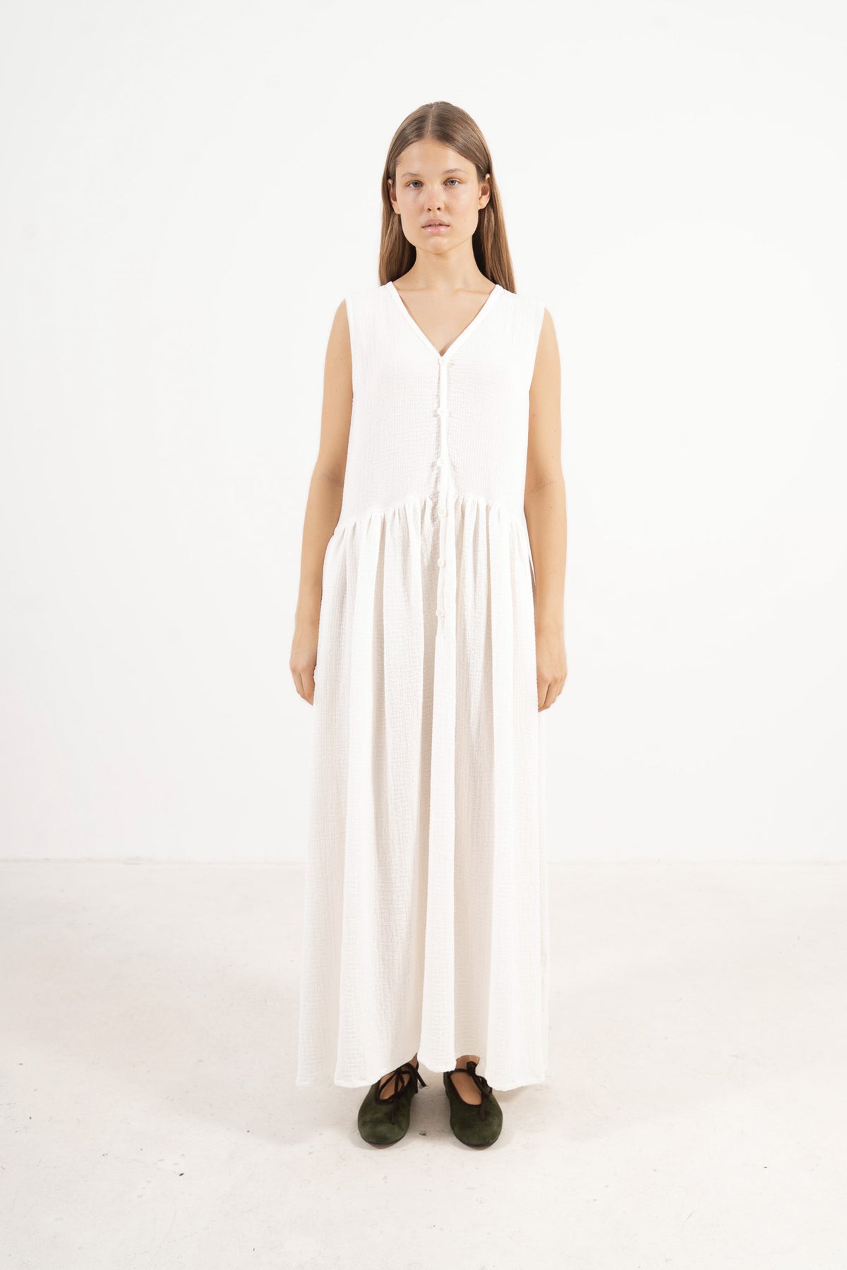 An elegant front view of the MOCHA Nuage long dress, meticulously crafted from the finest pure soft cotton, draped beautifully upon a pristine white floor.
