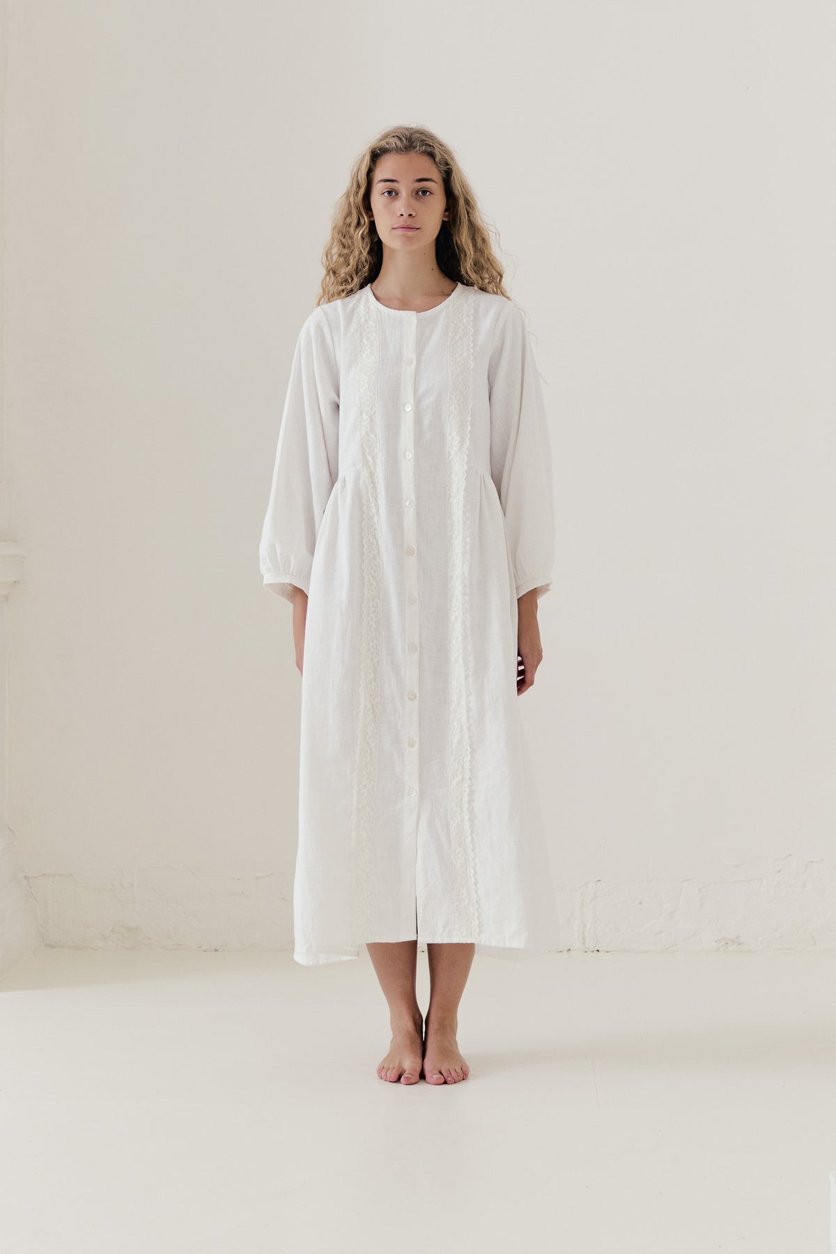 The Madeleine Dress from the POÈME La Clémence collection by MOCHA, showcasing an understated presence and gentle structure in a front view.