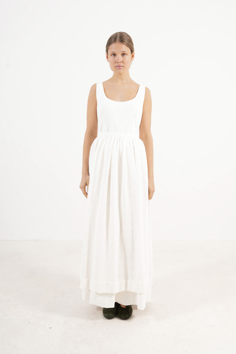 Le Tablier Long Apron from the POÈME La Cuisine line by MOCHA, highlighting the clean silhouette and delicate volants in a front lookbook shot.