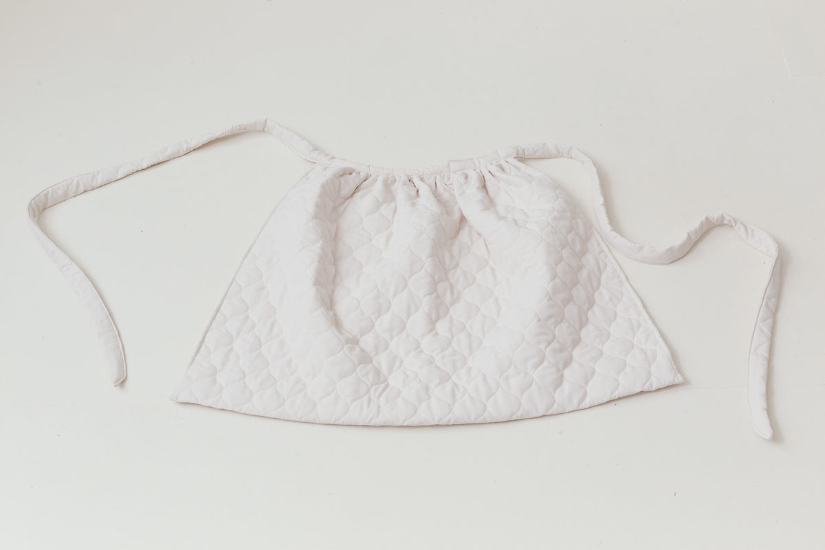 Detailed close-up focusing on the premium pure cotton weave and authentic tactile texture of the MOCHA Le Tablier de Poésie.