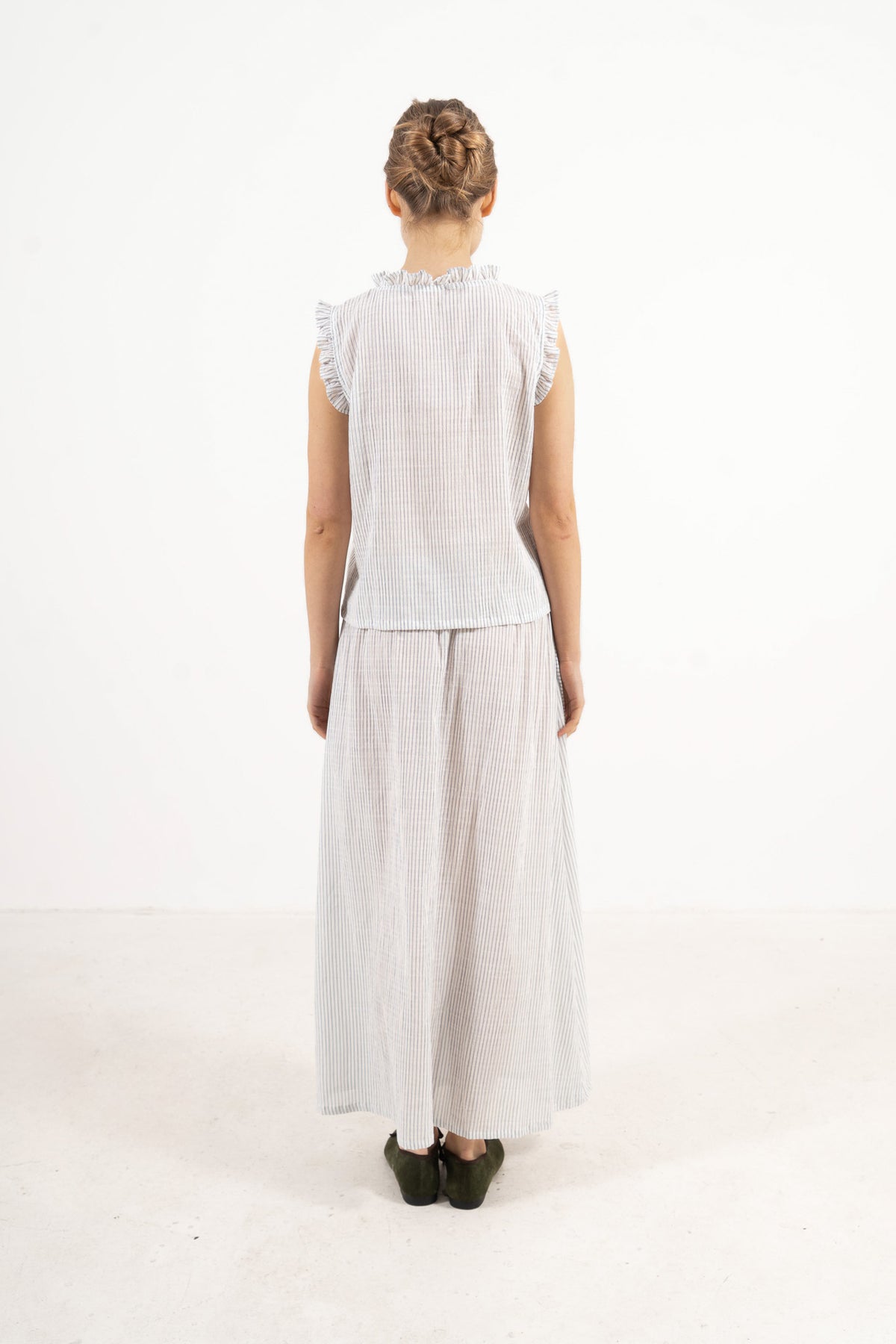 Back view of the timeless long cotton set on a model, capturing a soft world of ease inspired by air, movement, and gentle days.
